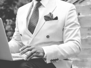 Man In White Suit Using Laptop